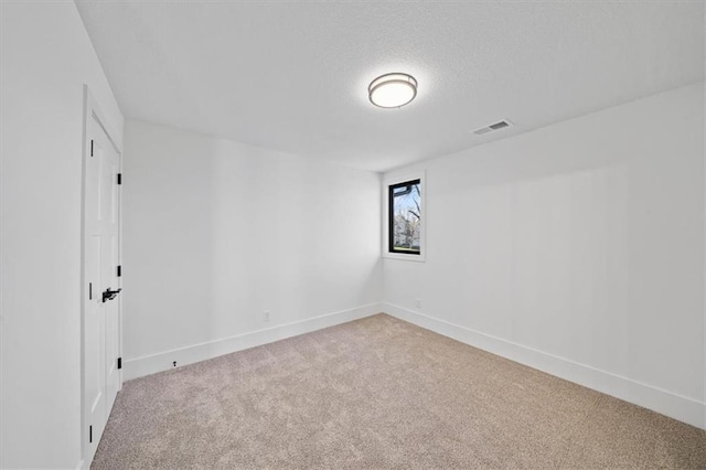 carpeted empty room with a textured ceiling