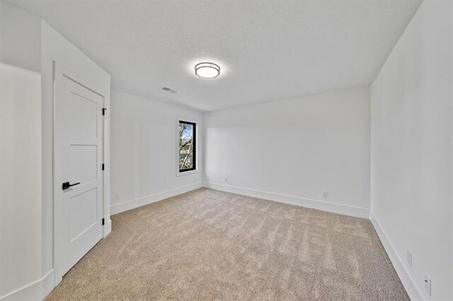 carpeted empty room featuring a textured ceiling