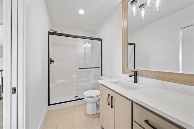 bathroom with tile patterned floors, vanity, a shower with shower door, and toilet