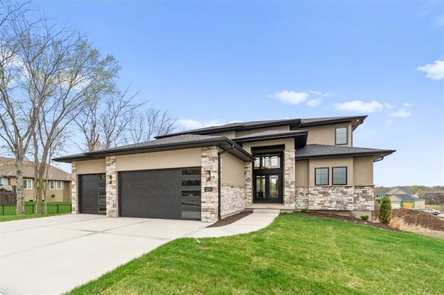 prairie-style home with stone siding, concrete driveway, stucco siding, a front lawn, and a garage