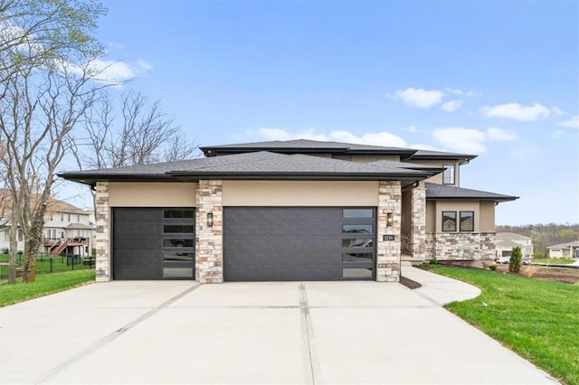 prairie-style house with stone siding, driveway, a front lawn, and an attached garage