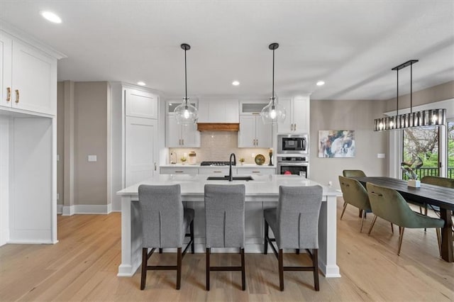 kitchen featuring white cabinetry, light countertops, a sink, and appliances with stainless steel finishes