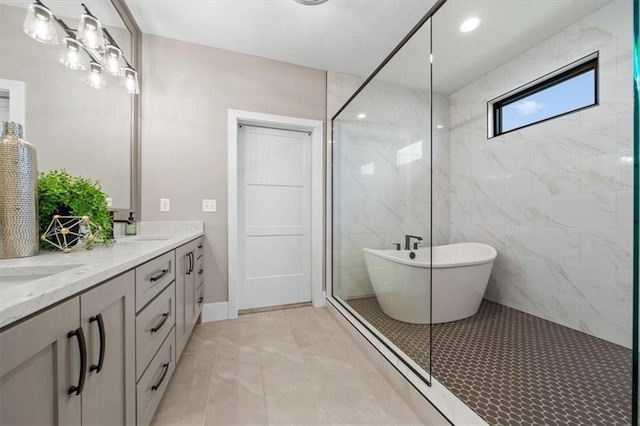 full bath featuring a freestanding tub, a sink, a marble finish shower, baseboards, and double vanity