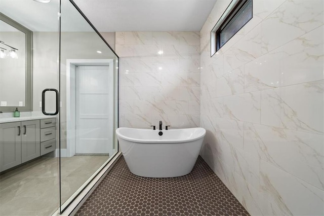 full bathroom featuring tile walls, a soaking tub, a shower, tile patterned floors, and vanity