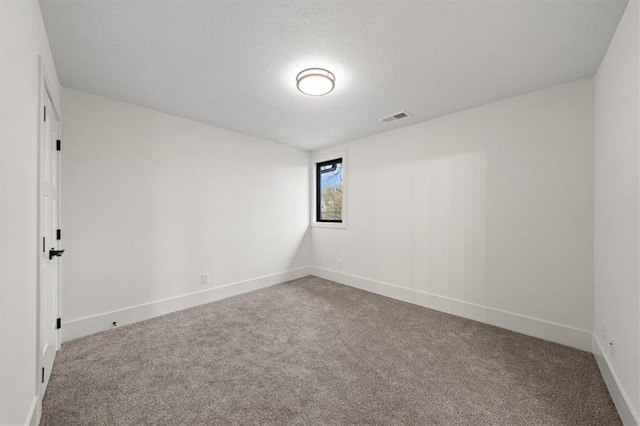 unfurnished room with baseboards, visible vents, and carpet flooring