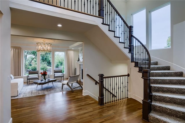 stairs featuring dark wood-type flooring and a notable chandelier