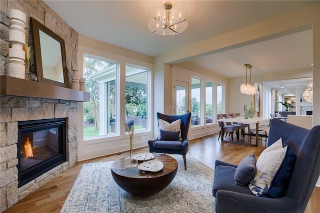 living room featuring an inviting chandelier, wood-type flooring, and a fireplace