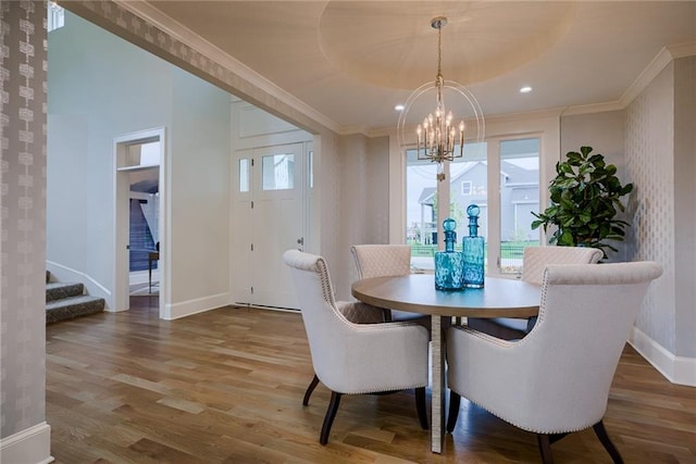 dining area featuring ornamental molding, an inviting chandelier, and hardwood / wood-style floors