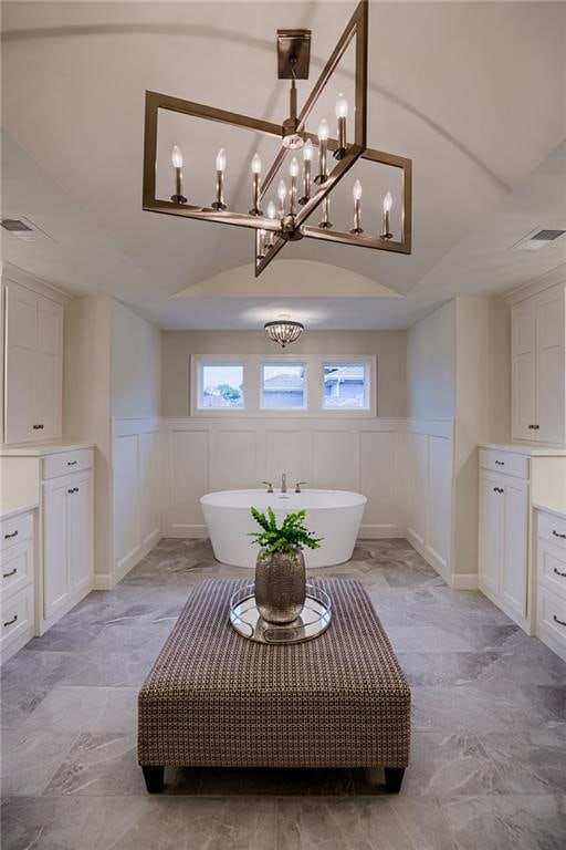 bathroom featuring a tub, vanity, a notable chandelier, and tile flooring