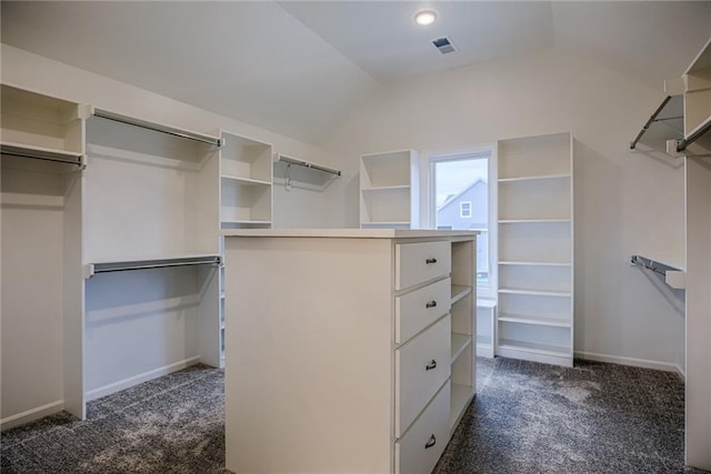 spacious closet with lofted ceiling and dark carpet