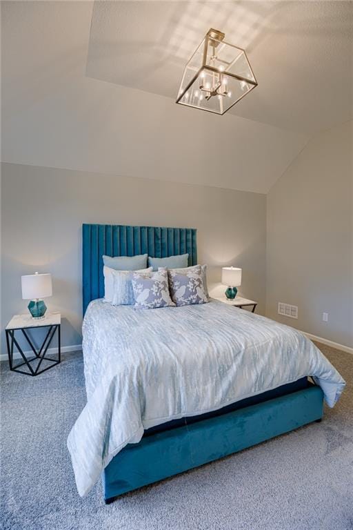 bedroom featuring lofted ceiling, carpet flooring, and a chandelier