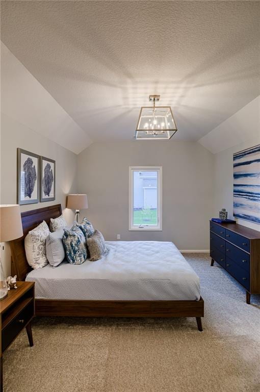 carpeted bedroom featuring a textured ceiling, vaulted ceiling, and a notable chandelier