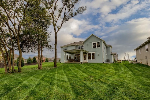 rear view of house featuring a yard and central air condition unit