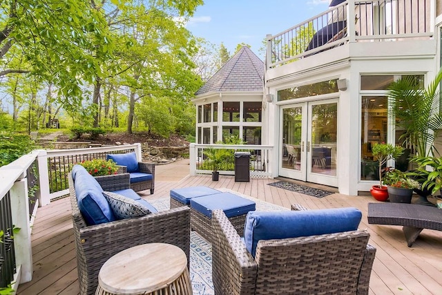 wooden terrace featuring an outdoor living space and a sunroom