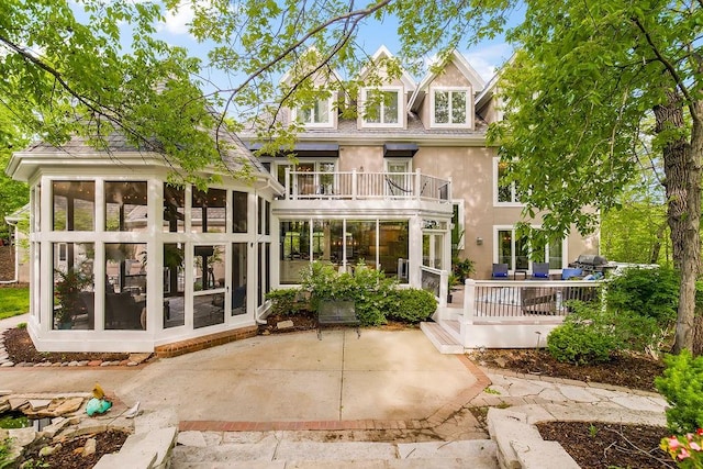 back of house featuring a patio, a balcony, and a sunroom