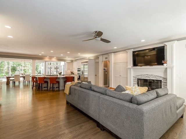 living room with a fireplace, ornamental molding, and dark hardwood / wood-style flooring