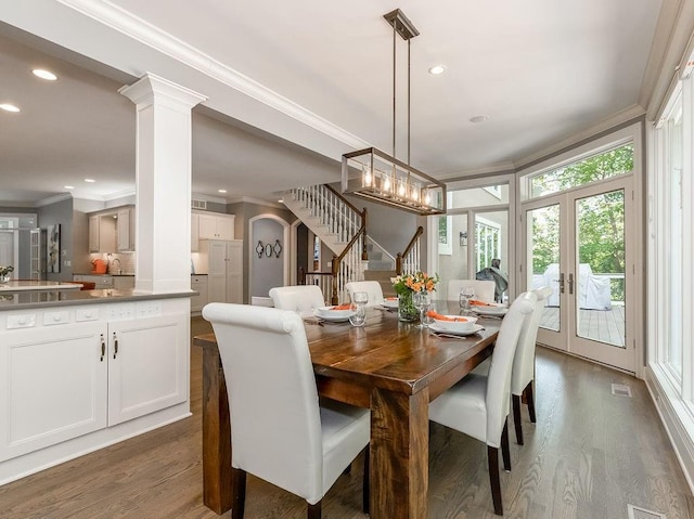 dining space with decorative columns, ornamental molding, dark hardwood / wood-style flooring, and french doors