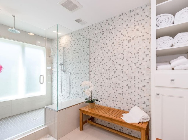 bathroom featuring tile patterned flooring, tile walls, and tiled shower