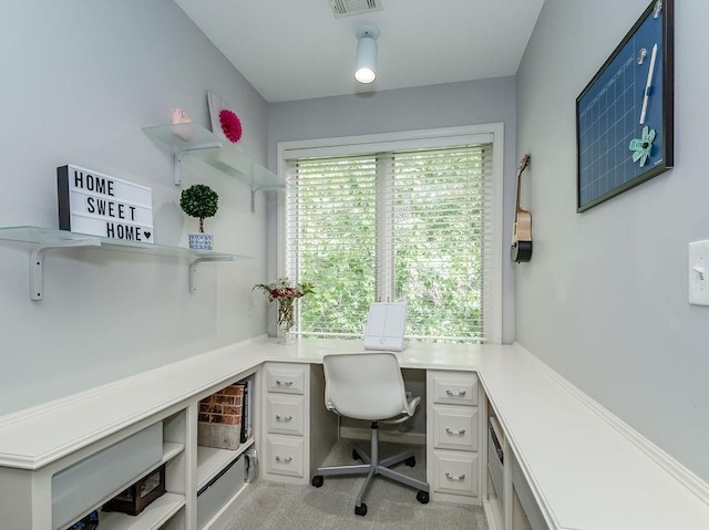 office with light carpet and built in desk