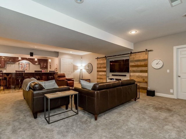 carpeted living room featuring bar area and a barn door