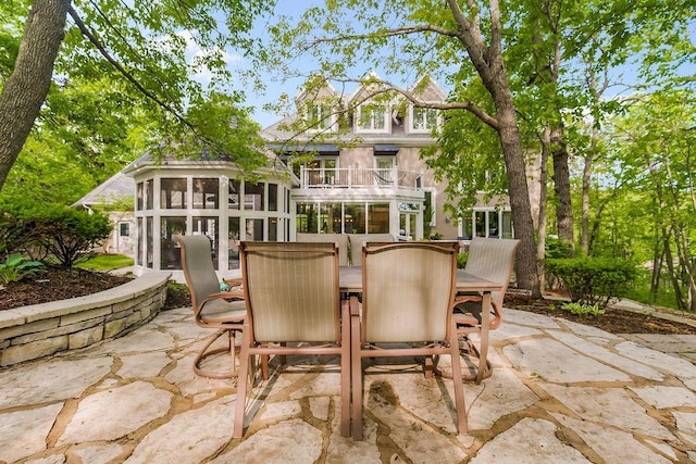 view of patio / terrace with a sunroom and a balcony