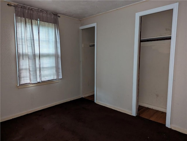 unfurnished bedroom with dark wood-type flooring and a closet