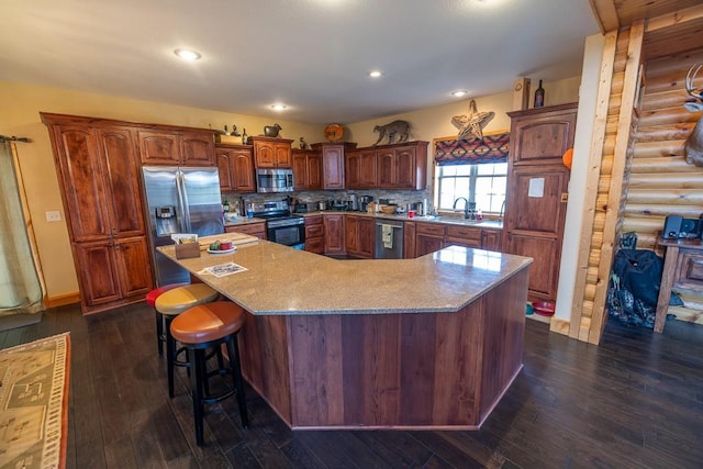 kitchen with a kitchen island, appliances with stainless steel finishes, dark hardwood / wood-style flooring, and backsplash