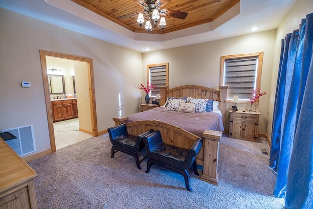 bedroom featuring ensuite bath, a raised ceiling, wood ceiling, light colored carpet, and ceiling fan