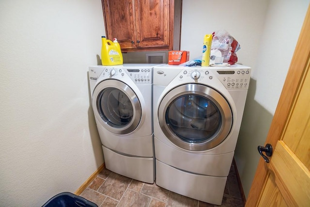 washroom with cabinets, washer hookup, light tile floors, and washer and clothes dryer