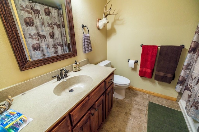 bathroom with tile flooring, vanity, and toilet