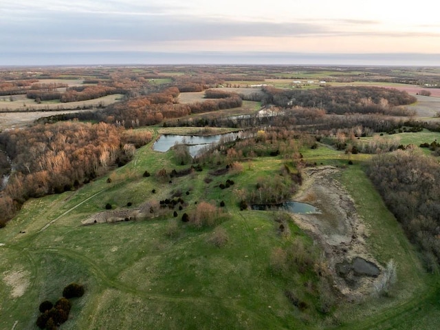 aerial view at dusk featuring a water view