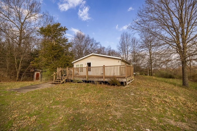 rear view of house with a wooden deck and a lawn