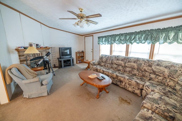 carpeted living room with crown molding, ceiling fan, a textured ceiling, and a fireplace