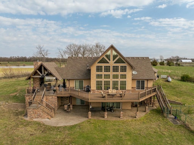 rear view of house featuring a patio area, a deck, and a lawn