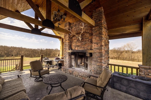 view of terrace featuring an outdoor stone fireplace and ceiling fan