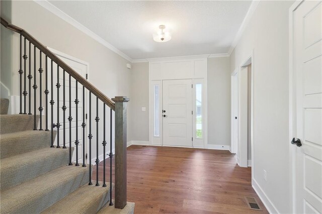 foyer with crown molding and wood-type flooring