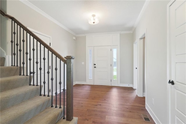 entrance foyer featuring dark wood-style floors, baseboards, stairway, and crown molding