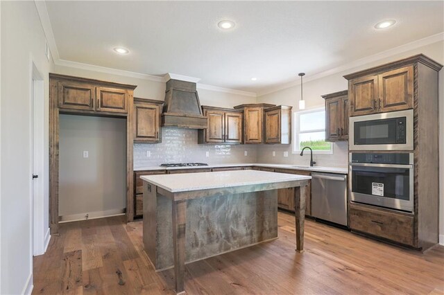 kitchen with wood-type flooring, premium range hood, decorative backsplash, and stainless steel appliances