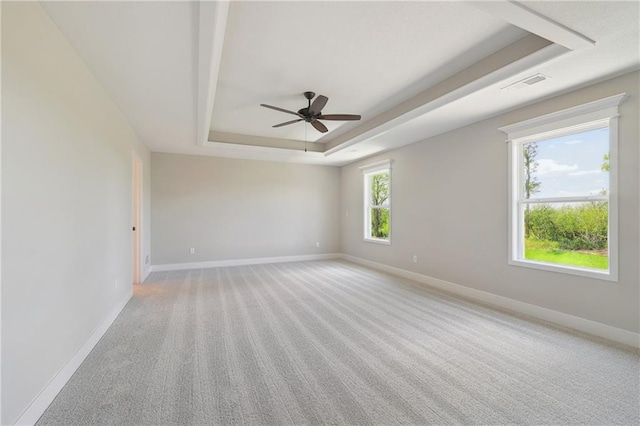 carpeted spare room featuring ceiling fan and a tray ceiling