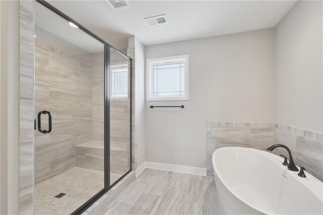 bathroom with shower with separate bathtub and tile patterned floors