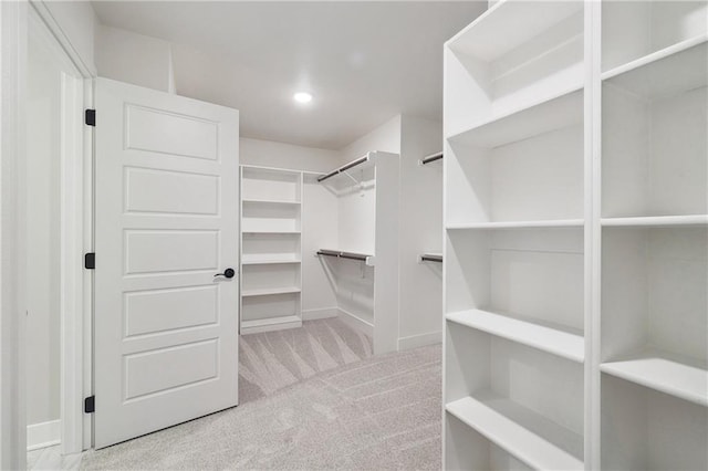 walk in closet featuring light carpet