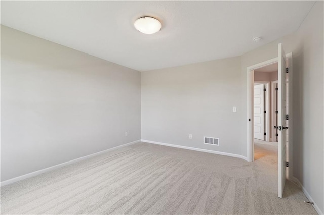 spare room featuring light colored carpet