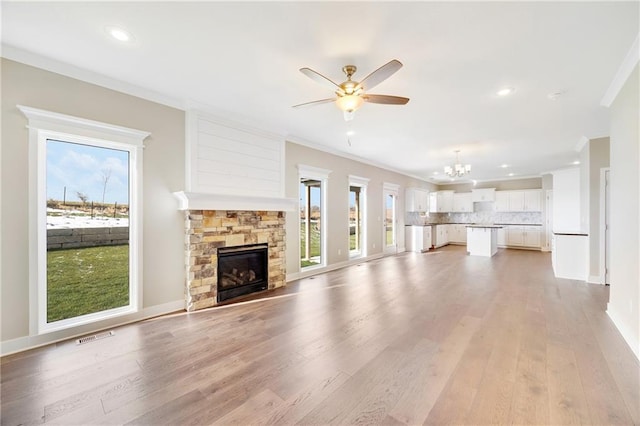 unfurnished living room featuring a fireplace, light hardwood / wood-style flooring, and a healthy amount of sunlight