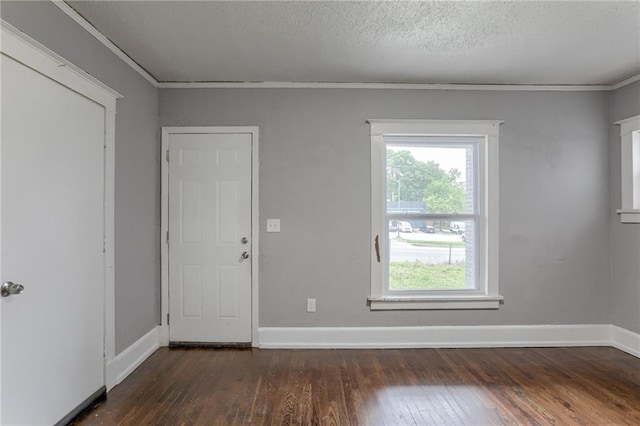 spare room featuring crown molding, a textured ceiling, and dark hardwood / wood-style flooring