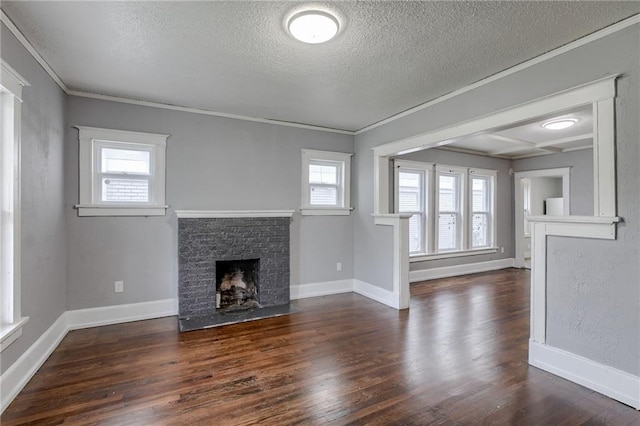 unfurnished living room featuring a textured ceiling, ornamental molding, a brick fireplace, and dark hardwood / wood-style flooring