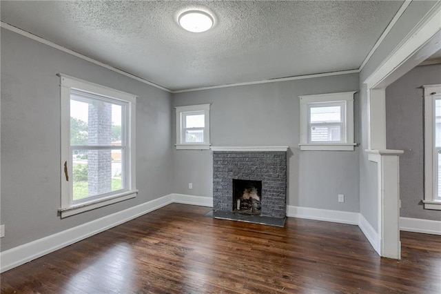 unfurnished living room featuring a healthy amount of sunlight, dark wood-type flooring, a textured ceiling, and a fireplace