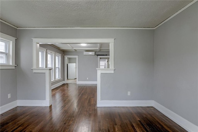 unfurnished room with a wall mounted AC, a textured ceiling, and dark hardwood / wood-style flooring