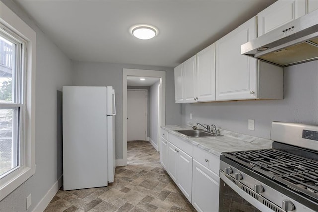 kitchen with white fridge, range with gas cooktop, light tile floors, sink, and white cabinets