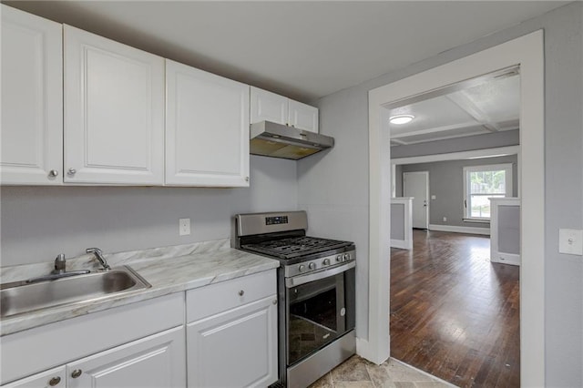 kitchen with white cabinetry, light stone countertops, stainless steel gas range oven, light wood-type flooring, and sink