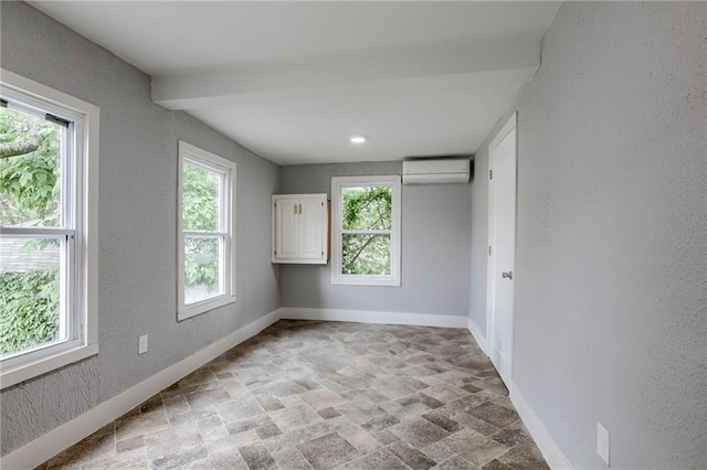 spare room with a wealth of natural light, a wall mounted AC, and tile flooring